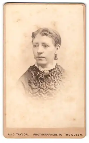 Fotografie A. & G. Taylor, Newcastle, Frau mit Brosche am Kragen trägt Ohrringe und Schmuckkragen