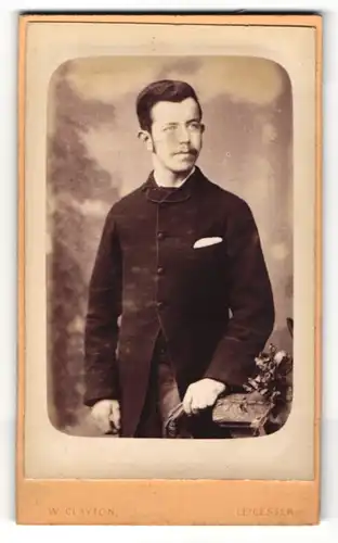 Fotografie W. Clayton, Leicester, Portrait bürgerlicher Herr in modischer Kleidung an Sockel gelehnt