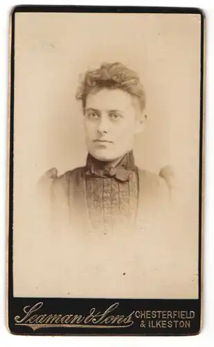 Fotografie Seaman & Sons, Chesterfield, Portrait schönes Fräulein mit lockigem Haar und Schleife am Kragen