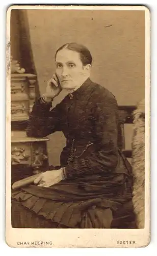 Fotografie Chas. Keeping, Exeter, Portrait bürgerliche Dame mit Buch am Schreibtisch sitzend