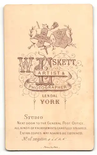 Fotografie W. Eskett, York, Portrait kleines Mädchen im weissen Kleid auf Fell sitzend