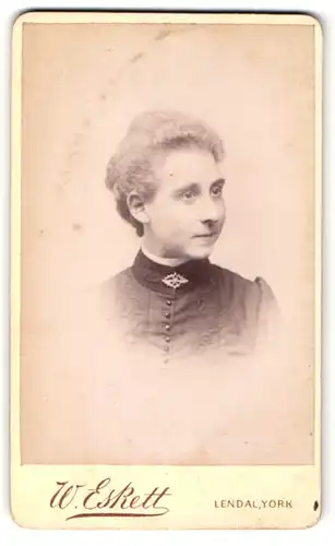 Fotografie W. Eskett, York, Portrait junge Dame in hübscher Kleidung mit Kragenbrosche