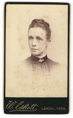 Fotografie W. Eskett, York, Portrait modisch frisierte Frau mit Brosche am Kleid