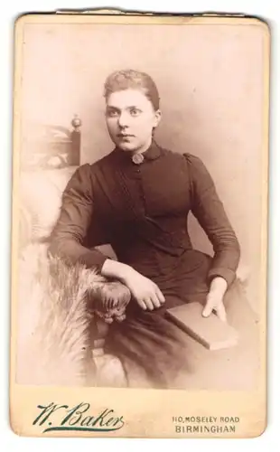 Fotografie W. Baker, Birmingham, Portrait junge Frau in schwarz mit Buch