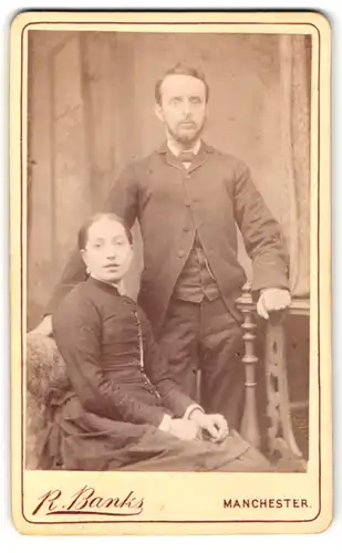 Fotografie R. Banks, Manchester, Portrait bürgerliches Paar in hübscher Kleidung