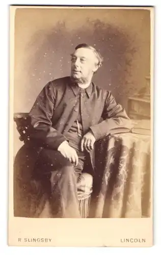 Fotografie R. Slingsby, Lincoln, Portrait elegant gekleideter Herr mit Bart am Tisch sitzend