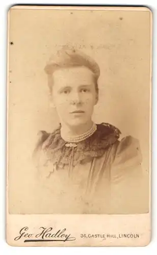 Fotografie Geo. Hadley, Lincoln, Portrait junge Dame im eleganten Kleid mit Perlenkette