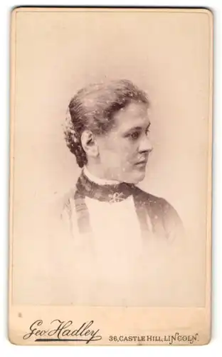 Fotografie Geo. Hadley, Lincoln, Portrait bürgerliche Dame mit Flechtfrisur und Kragenbrosche