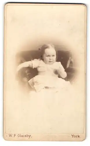 Fotografie W. P. Glaisby, York, Portrait sitzendes Mädchen im weissen Kleid mit Ball