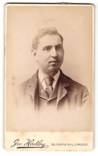 Fotografie Geo. Hadley, Lincoln, Portrait bürgerlicher Herr im Anzug mit Krawatte und Bart