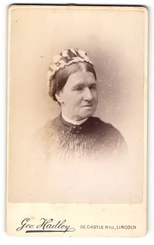 Fotografie Geo. Hadley, Lincoln, Portrait ältere Dame mit Haube und Kragenbrosche