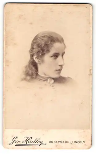 Fotografie Geo. Hadley, Lincoln, Portrait junge Dame mit langen Haaren und Kragenbrosche