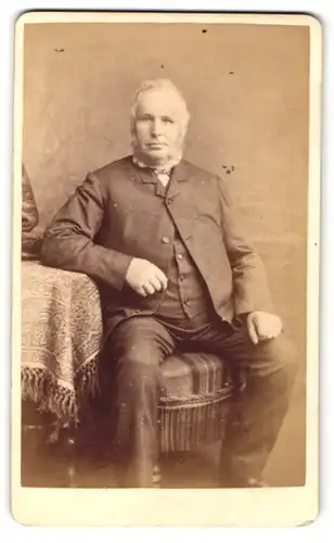 Fotografie R. Slingsby, Lincoln, Portrait bürgerlicher Herr mit Bart am Tisch sitzend