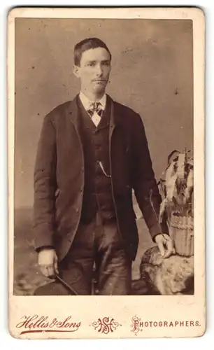 Fotografie Hellis & Sons, London, Portrait bürgerlicher Herr in Anzugjacke mit Fliege und Hut