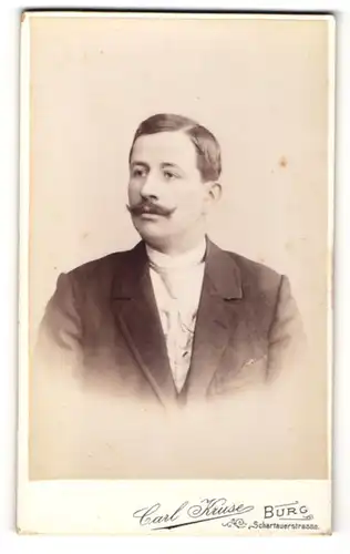 Fotografie Carl Kruse, Burg, Portrait junger Herr mit Oberlippenbart in Anzug mit Krawatte