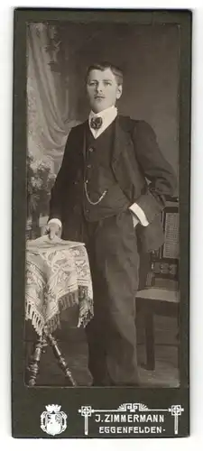 Fotografie J. Zimmermann, Eggenfelden, Portrait modisch gekleideter Herr mit Zeitung
