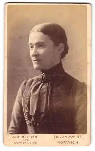 Fotografie Albert E. Coe, Norwich, Portrait Frau mit zurückgebundenen Haaren in dunklem Kleid