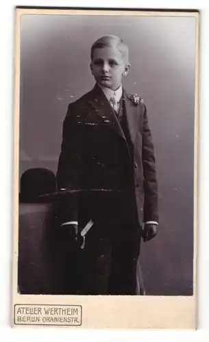 Fotografie Atelier Wertheim, Berlin, Junger Bursche in dunklem Anzug mit schwarzen Lederhandschuhen