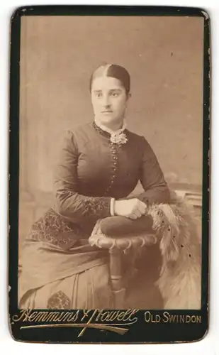 Fotografie Hemmins & Howell, Old Swindon, Junge Dame mit strengem Zopf in hochgeknöpftem Kleid