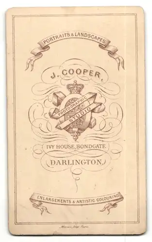 Fotografie J. Cooper, Darlington, Mann mit Koteletten im Anzug auf Stuhl sitzend