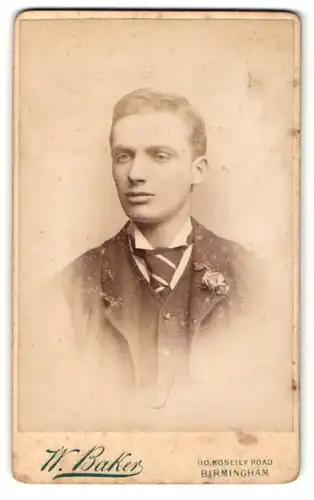 Fotografie W. Baker, Birmingham, Portrait junger Mann mit gekämmten Haaren im Anzug mit Blume und Fliege