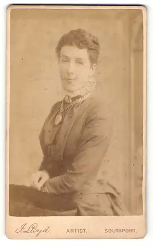 Fotografie J. Lloyd, Southport, Portrait bürgerliche Dame in eleganter Kleidung mti Amulett