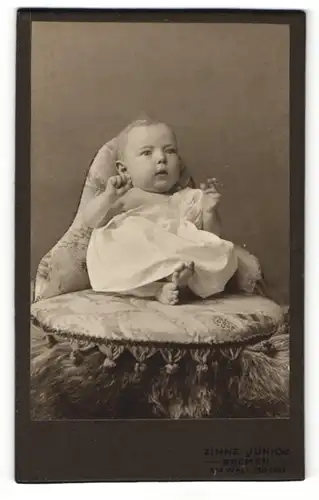 Fotografie Zinne junior, Bremen, Portrait sitzendes Baby im weissen Hemd mit nackigen Füssen