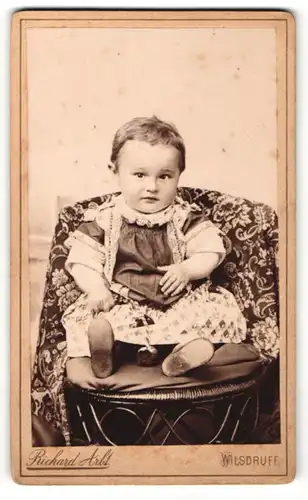 Fotografie Richard Arlt, Wilsdruff, Portrait sitzendes Kleinkind im hübschen Kleid mit kurzen Haaren