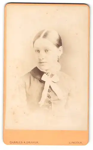 Fotografie Charles A. Draper, Lincoln, Portrait einer jungen Frau im Kleid mit weisser Schleife