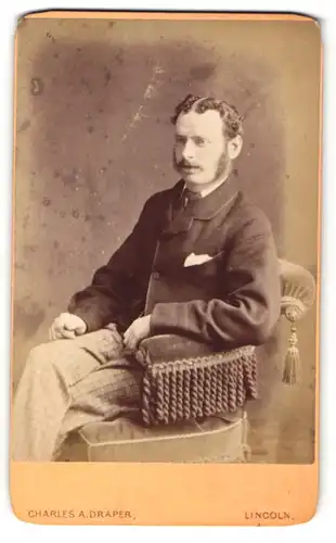 Fotografie Charles A. Draper, Lincoln, Mann mit Schnurrbart und Backenbart sitzt in einem Stuhl