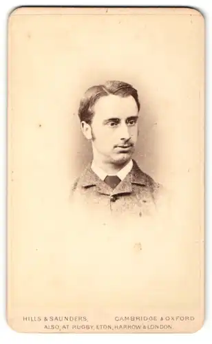 Fotografie Hills & Saunders, Cambridge, Portrait dunkelhaariger charmanter Mann im grauen Jackett