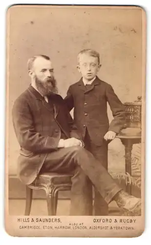 Fotografie Hills & Saunders, Oxford, Portrait stattlicher Herr mit Vollbart & frecher Bube im Anzug