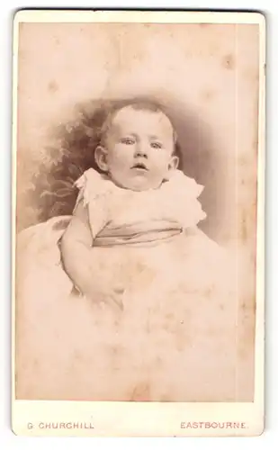 Fotografie G. Churchill, Eastbourne, Portrait zuckersüsses kleines Mädchen im weissen Taufkleidchen