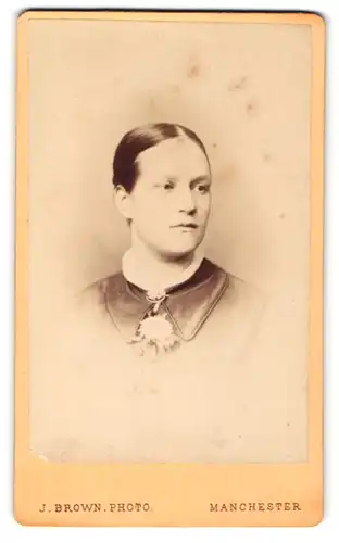 Fotografie J. Brown, Manchester, Portrait brünettes Fräulein mit Brosche und Blume