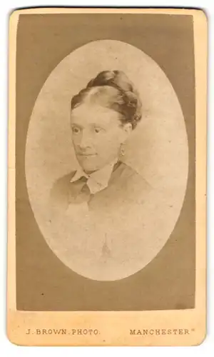 Fotografie J. Brown, Manchester, Portrait freundlich blickende Dame mit Flechtzopf