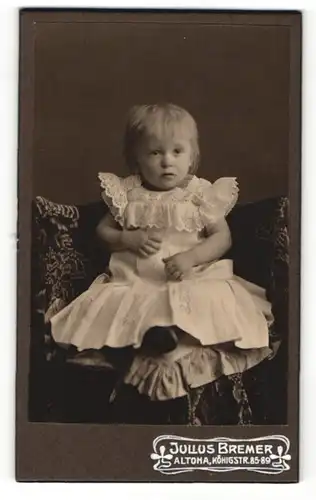 Fotografie Julius Bremer, Altona, Kleinkind in weissem Spitzenkleid auf Stuhl