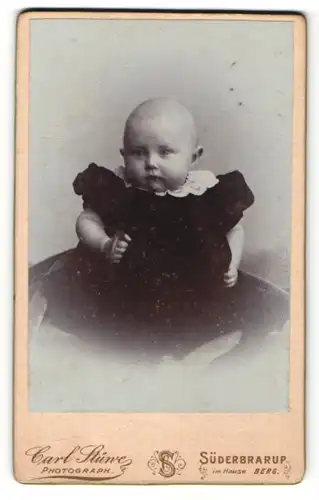 Fotografie Carl Stüwe, Süderbrarup, Baby in schwarzem Kleid