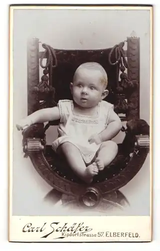 Fotografie Carl Schäfer, Elberfeld, Baby auf Samtstuhl sitzend