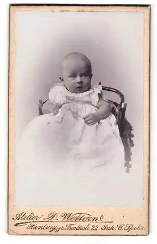 Fotografie Atelier D. Wettern, Hamburg, Baby in weissem Kleid auf Stuhl