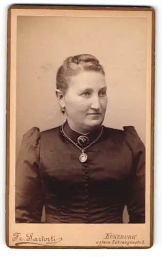 Fotografie Fr. Sartorti, Lüneburg, Portrait bürgerliche Dame mit Hochsteckfrisur und Amulett