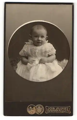 Fotografie Jos. Minet, Elmshorn, Portrait Säugling in Taufkleid