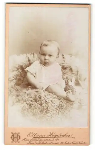 Fotografie Ottmar Heydecker, Hamburg, Portrait Baby im weissen Hemdchen auf einem Fell sitzend