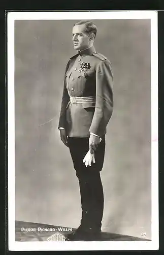 AK Schauspieler Pierre Richard-Willm in Uniform mit Orden und Handschuhen steht stramm