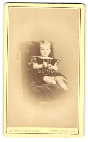 Fotografie Lambert Weston & Son, Folkestone, Portrait sitzendes Mädchen im hübschen Kleid mit Seitenscheitel