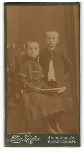 Fotografie Albin Leidler, Kirchberg i/S., Mädchen im Kleid sitzend und Junge im Anzug daneben stehend