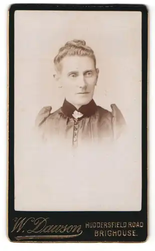 Fotografie W. Dawson, Brighouse, Dame mit auf dem Kopf zusammengebundenen Haaren trägt Kleid mit dunklem Kragen