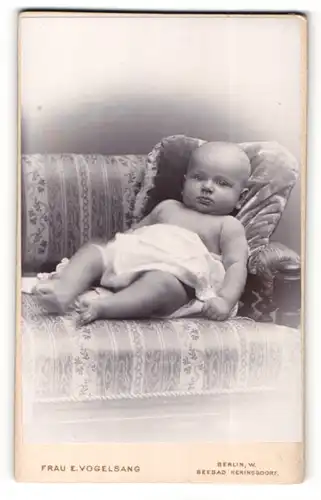 Fotografie E. Vogelsang, Berlin-W., Portrait liegendes Baby im weissen Hemd mit nackigen Füssen