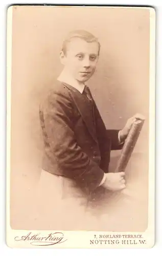 Fotografie Arthur King, Notting Hill-W., Portrait junger Mann in Anzugjacke mit Buch