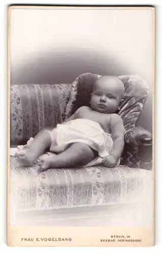 Fotografie Frau E. Vogelsang, Berlin-W, Portrait Säugling auf Sitzmöbel