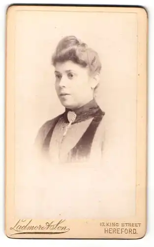 Fotografie Ladmore & Son, Hereford, Portrait junge Dame mit Hochsteckfrisur und Kragenbrosche